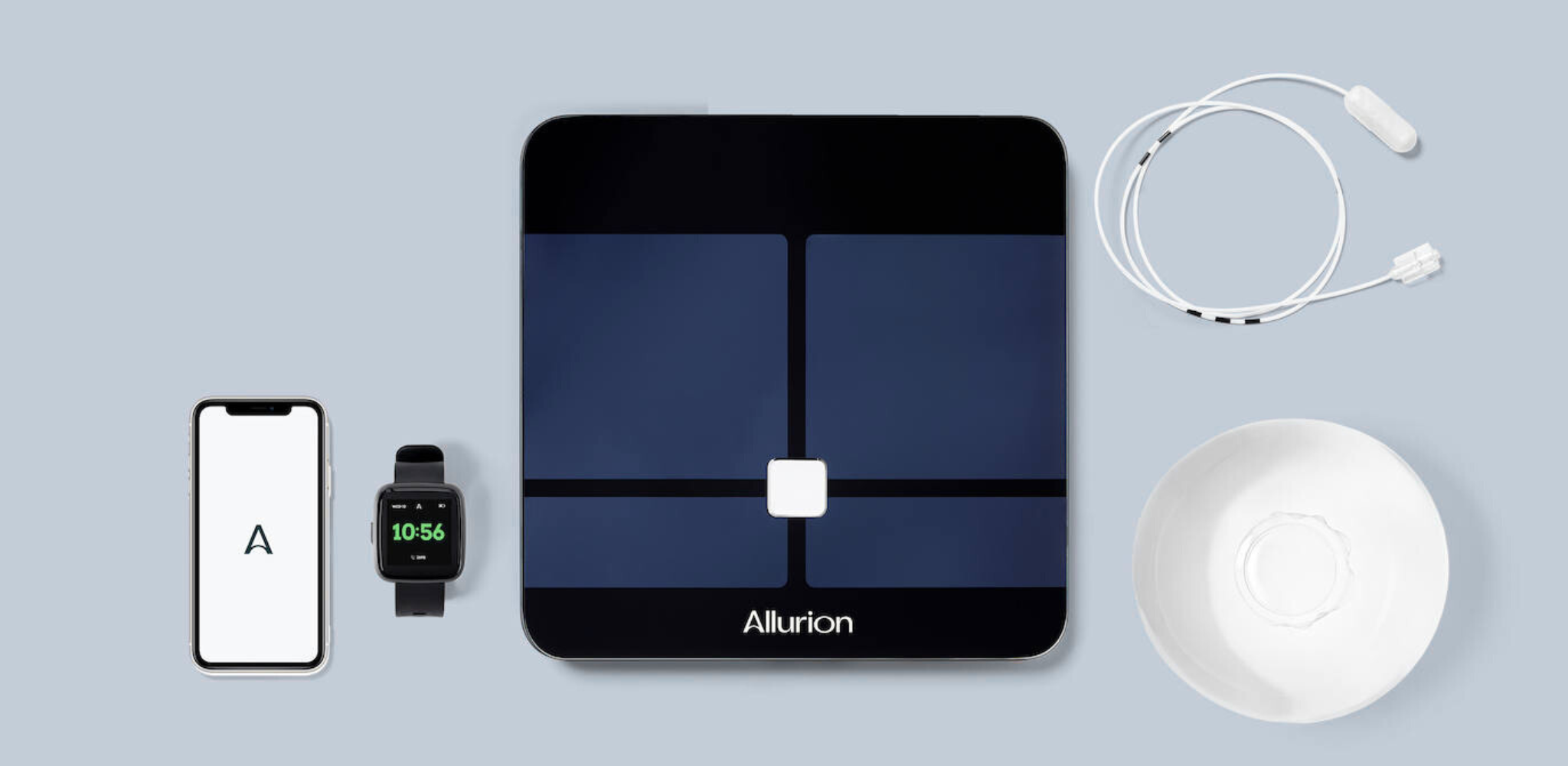 Un balón intragástrico ingerible de Allurion con la báscula, el reloy y la App para hacer el seguimiento de pérdida de peso